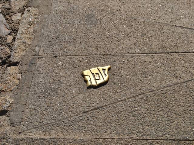 Placa met&aacute;lica de se&ntilde;alizaci&oacute;n en el suelo en Juder&iacute;a Vieja